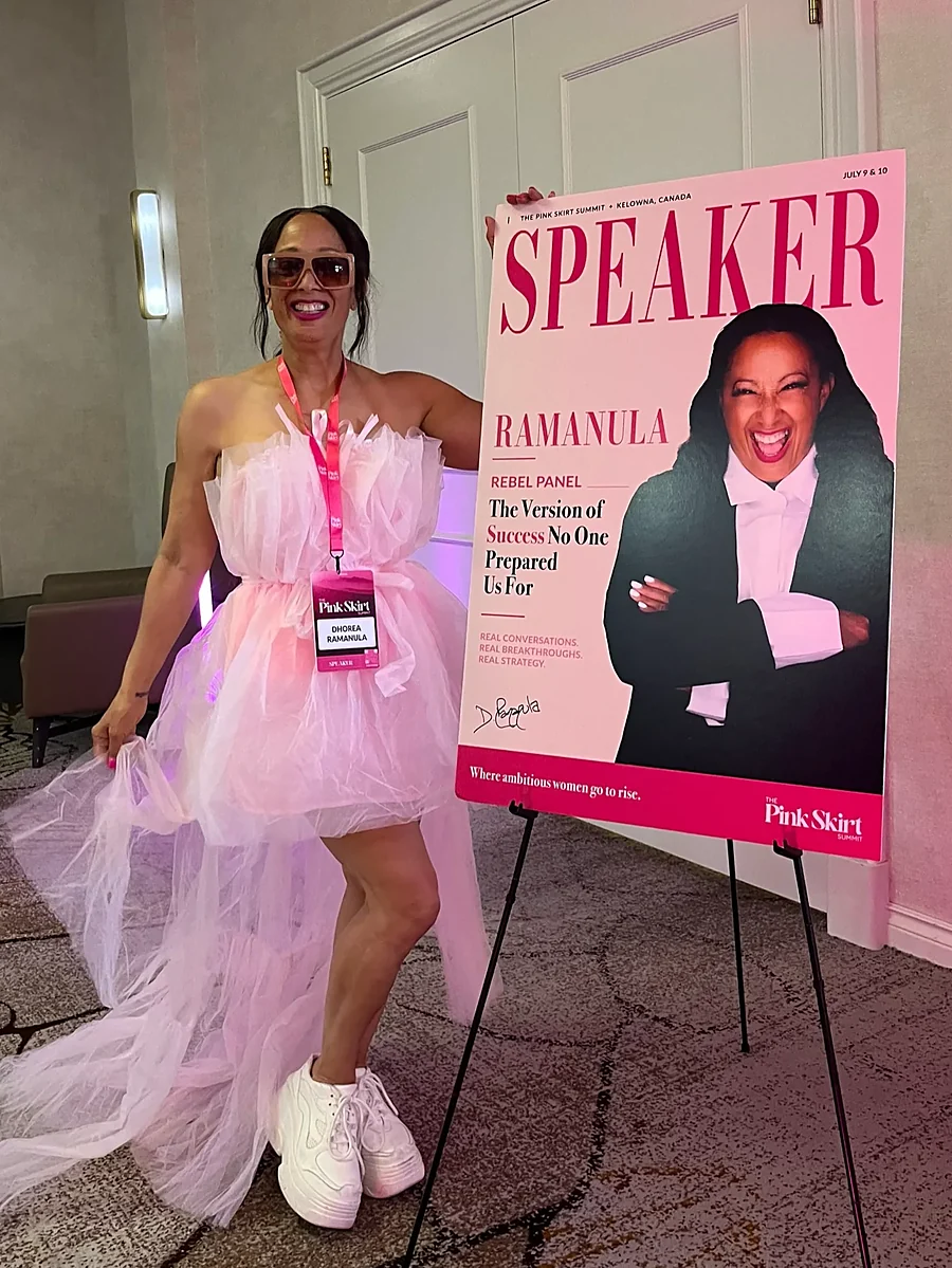 Dhorea Ramanula beside her speaker poster at the Pink Skirt Summit